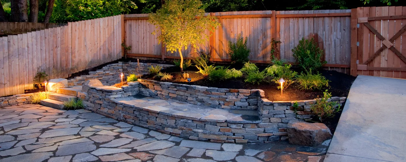Outdoor stone patio and landscape lighting featured in Roots 'n Shoots archive